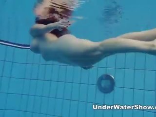 Redheaded schoonheid zwemmen naakt in de zwembad
